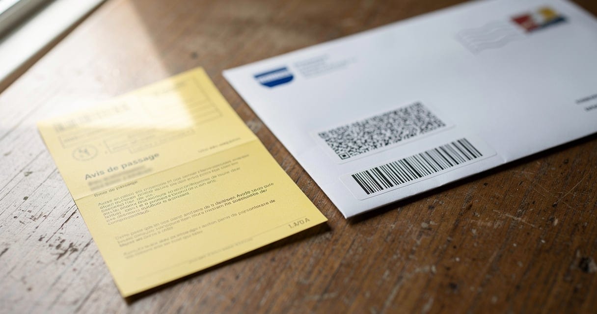 Avis de passage La Poste pour un recommandé 2C posé sur une table en bois